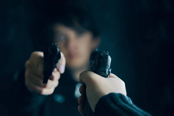 Mano de hombre con pistola apuntando a criminal con revólver. — Foto de Stock