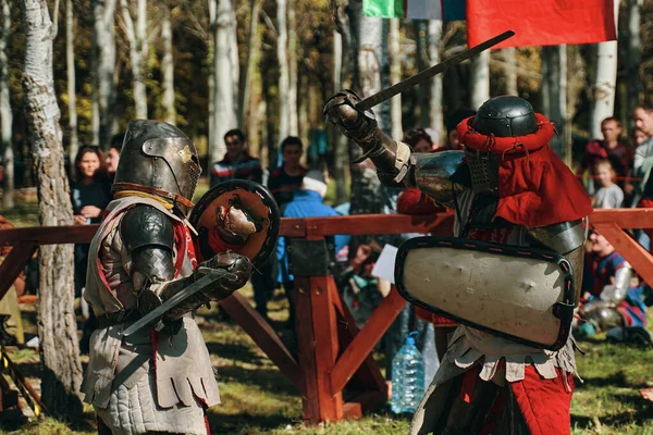 Bataille de chevaliers en armure sur des épées devant le public. — Photo