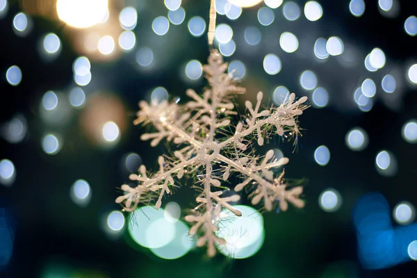 Schneeflocke zwischen Weihnachtslichtern. — Stockfoto