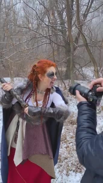 Male photographer shoots female Viking model in winter. — Stock Video