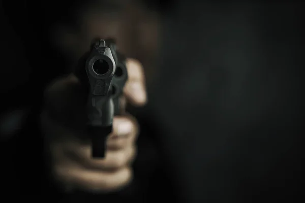 Muzzle of gun in mans hand is pointed at camera. — Stock Photo, Image