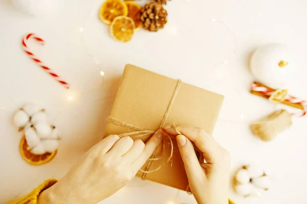 Frau bindet Schleife an Weihnachtsgeschenk. — Stockfoto