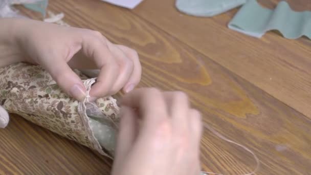 Femmes coud une jolie poupée en tissu. — Video