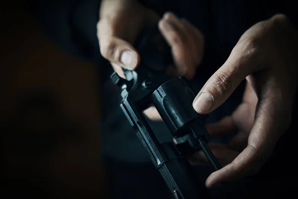 Mens händer kontrollera efter kulor i revolver fat. — Stockfoto