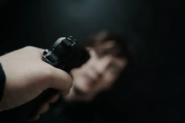 Pierwszy rzut oka na broń skierowaną do młodego człowieka. — Zdjęcie stockowe
