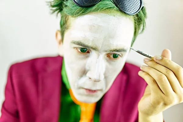 Cosplayer cara pinta seu rosto com escova. — Fotografia de Stock