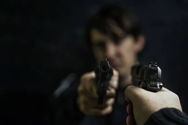 Mans hand with pistol pointed at criminal with revolver. — Stock Photo, Image