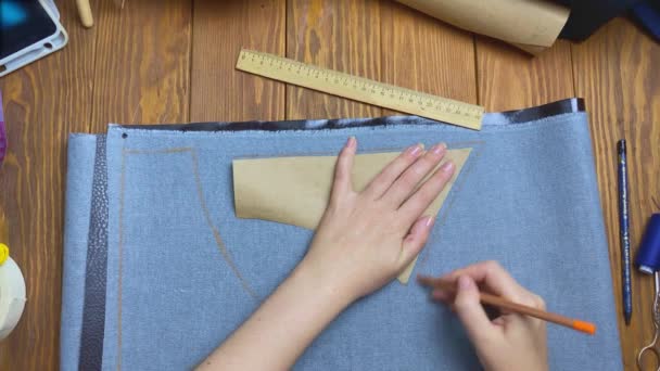 여성들의 손은 연필로 생태 가죽 위에크 레프트 종이 패턴을 그리고 있습니다. — 비디오