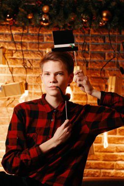 Silindir şapkalı ve pipo kulübesinde poz veren yakışıklı adam..