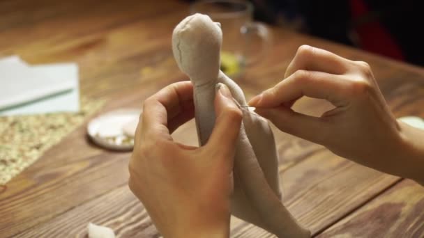 Women sews a cute cloth doll. — Stock Video