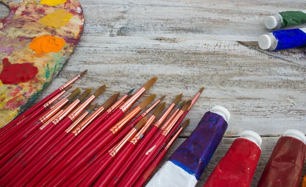 Pincéis, pintura, paleta sobre fundo de madeira — Fotografia de Stock