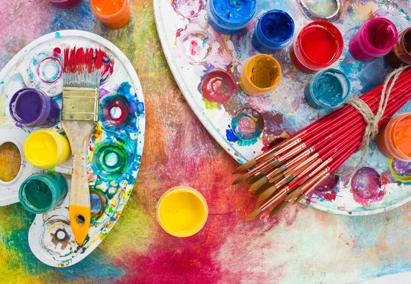 Pitture, pennelli e tavolozza sullo sfondo colorato . — Foto Stock