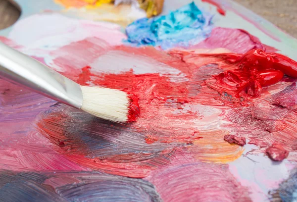 The brush and palette of paints.