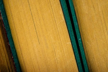 Sıraya dizilmiş eski kitaplar yığını.