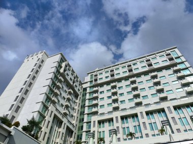 Makassar-Endonezya 18 Ekim 2025 Beyaz gökyüzü altında alçak bir açıdan bakan sayısız pencere ve balkonlu apartman veya yüksek binalar.