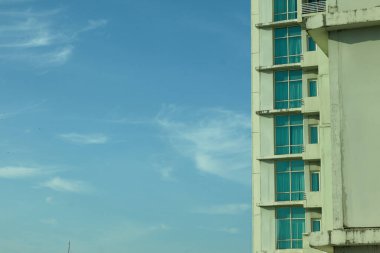 Makassar-Endonezya 18 Ekim 2025 Beyaz gökyüzü altında alçak bir açıdan bakan sayısız pencere ve balkonlu apartman veya yüksek binalar.