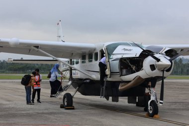 Balikpapan-Endonezya 22 Ekim 2025 Beyaz gömlekli bir adam, küçük bir 