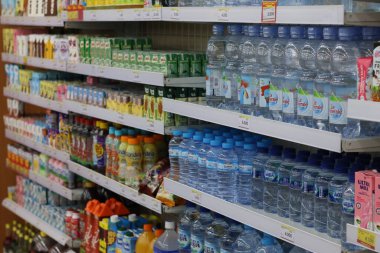 24 Ekim 2025 'te Balikpapan-Endonezya süpermarket raflarının önemli maden suyu markaları ve diğer renkli içecekler de dahil olmak üzere çeşitli şişelenmiş içeceklerle dolu olduğu uzun bir manzara.