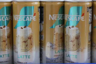 24 Ekim 2025 'te Balikpapan-Endonezya' da bir süpermarket rafında markalaşma, ürün imajı ve ambalaj detaylarını gösteren sarı Nescafe Latte konserve kahve içeceklerinin yakın çekimi yapıldı..