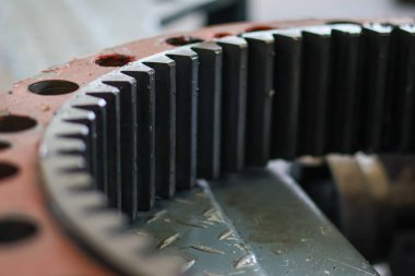 Yakın çekim görüntüsü, ağır makinelerin son sürüş ünitelerinde güç transferi için kritik bir bileşen olan büyük endüstriyel halka dişlerinin keskin ve hassas dişlerini vurguluyor..