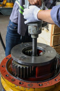Endüstriyel teknisyenler, bir tamir atölyesinde sökülme veya kritik bakım sırasında son sürüş bileşeninin büyük bir dişli montajı üzerinde ağır basınçlı pnömatik anahtar veya hava etkisi kullanırlar..