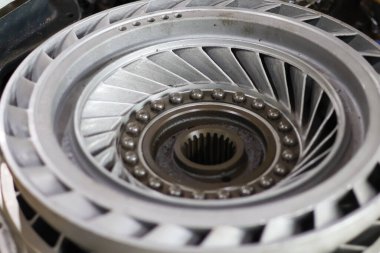 Karmaşık otomotiv mühendisliği ve hassas iletim onarımını sembolize eden merkezi eğimli ve açıkta duran bilyeli metalik tork dönüştürücü ya da itici güç montajı.