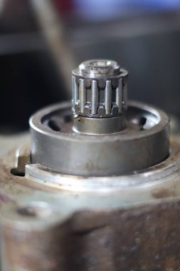 İç dişleri ve mekanik giysisi bulunan merkezi çelik sabitleme şaftı veya gezegen teması tamir etmek için kirli bir otomotiv nakil kaplamasına monte edilmiş gezegen teması..