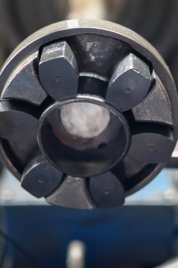 Sanayi enerji nakil temaları için ideal, karanlık, ağır, mekanik bir eşleşmenin veya merkezi delik ve iç içe geçmiş kauçuk veya polimer segmentleri ile esnek bir şaft eşleşmesinin yakın çekimi.