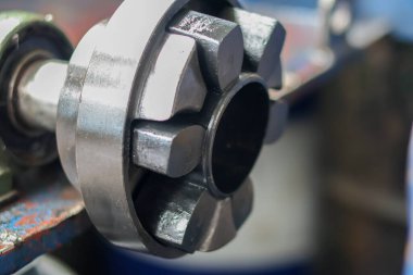 Sanayi enerji nakil temaları için ideal, karanlık, ağır, mekanik bir eşleşmenin veya merkezi delik ve iç içe geçmiş kauçuk veya polimer segmentleri ile esnek bir şaft eşleşmesinin yakın çekimi.