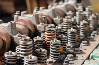 Parçalanmış, ağır paslanmış bir otomotiv motor silindirinin yakın çekimi. Bir tamircide mil yatakları, kapakçık yayları ve rockçı kolu montajlarını gösteriyor..