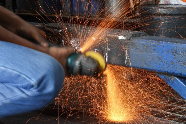 Parlak turuncu kıvılcımlar, el kamerası açılı öğütücüden inanılmaz bir şekilde uçar. Yavaş çekim yapan endüstriyel bir çekimde metali keser..