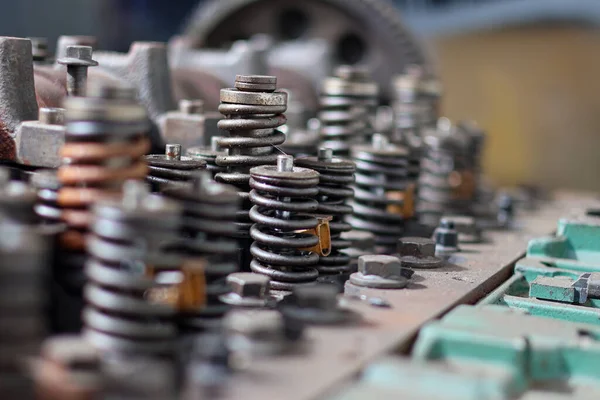 Parçalanmış, ağır paslanmış bir otomotiv motor silindirinin yakın çekimi. Bir tamircide mil yatakları, kapakçık yayları ve rockçı kolu montajlarını gösteriyor..