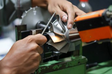 Bir teknisyenin ellerini bir turbo türbin tekerleği, profesyonel metal işçiliği ve mekanik motor onarım servisi için manüel dengeleme hassas bir dosya kullanarak kapat.