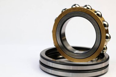 Altın pirinç kafesli endüstriyel çelik bilye ve ayrı metal halkalar. Büyük kopya alanı olan beyaz bir arka planda izole edilmiş.
