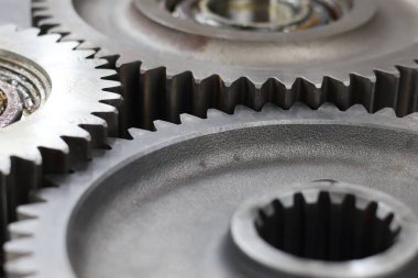 Metalik doku ve mekanik hassasiyet içeren birbirine kenetlenmiş çelik dişliler ve bilyelerin detaylı makrosu.