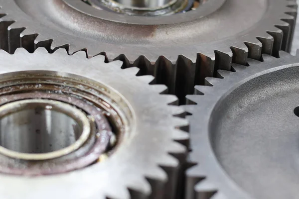 Metalik doku ve mekanik hassasiyet içeren birbirine kenetlenmiş çelik dişliler ve bilyelerin detaylı makrosu.