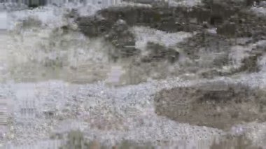 Kayalık bir çıkıntının üzerinden akan suyun üst görüntüsü doğal bir derede ya da nehirde beyaz köpük ve kabarcıklar oluşturur.