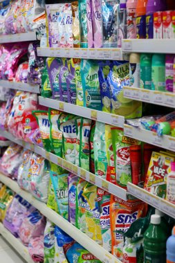 Balikpapan-Endonezya 01 Şubat 2026 Bir süpermarket koridorunda beyaz metal raflarda düzgün bir şekilde düzenlenmiş renkli keseler ve şişelerde çeşitli ev temizlik ürünleri.
