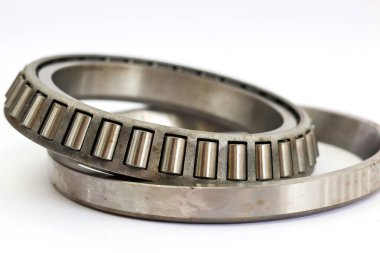 Ağır iş makineleri için beyaz arka planda izole edilmiş çelik silindirli endüstriyel paten montajını kapat..