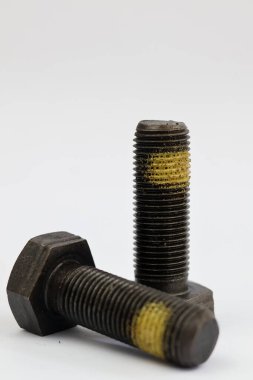 Beyaz arka planda izole edilmiş sarı iplikli iki ağır sanayi büyüsü cıvatası..