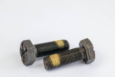 Beyaz arka planda izole edilmiş sarı iplikli iki ağır sanayi büyüsü cıvatası..