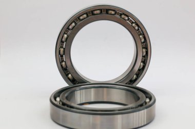 İki endüstriyel çelik bilye, bir ayakta duruyor ve bir tane de beyaz arka planda uzanıyor. Makineler ve otomotiv onarımı için profesyonel mekanik parça..