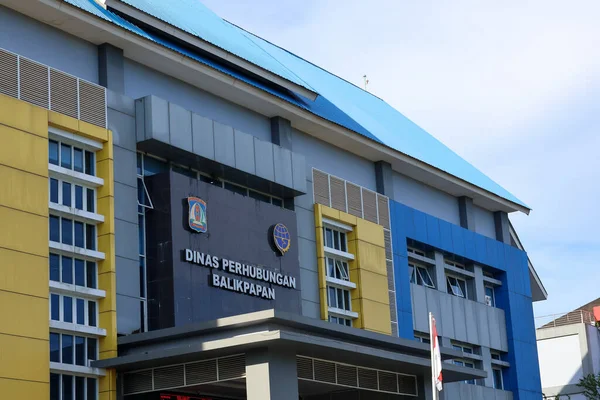 Endonezya-Balikpapan-Endonezya 05 Şubat 2026 Balikpapan Endonezya Ulaştırma Bakanlığı modern hükümet binası mavi ve sarı ön cephe tasarımı açık mavi gökyüzü altında park etmiş arabaların önünde.