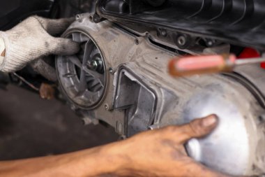 Tamirat ve tamirat sırasında motor motoru CVT sistemini kontrol eden tamirci elini kapat..