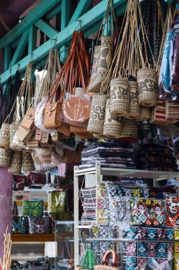 Çeşitli geleneksel Endonezya el yapımı el yapımı el yapımı çantaları ve bir hediyelik eşya dükkanında asılı duran ve karmaşık etnik kalıplar ve doğal malzemelerle....