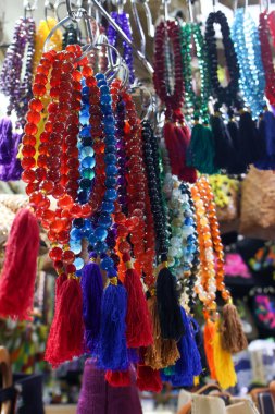 Geleneksel bir Endonezya hediyelik eşya pazarında asılı renkli ipek püsküllü güzel el yapımı kristal boncuk kolyeler..