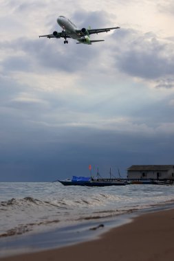 Geleneksel ahşap sürat teknesi tropikal ufukta bulutlu bir gökyüzünün altında sakin mavi denizde yol alıyor..