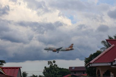 Balikpapan-Endonezya 17 Şubat 2026 Süper Hava Jet Airbus A320 ticari uçaklar, Endonezya 'nın yerleşim yerlerinin çatılarına inmek için alçaktan uçuyor..