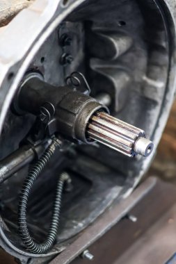 Çan kapağı içinde taşıyıcı montajı taşıyan, yağa bulanmış araç debriyaj sisteminin mekanik detaylarını gösteren, yalıtkan bir kamyon nakil şaftına yakın çekim..