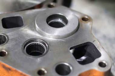 Endüstriyel mühendislik bileşenlerini bir araç nakil onarımı sırasında gösteren hassas iğne bilyeli ve sıvı limanlı ağır metalik hidrolik pompa yuvasının yakın çekimi.